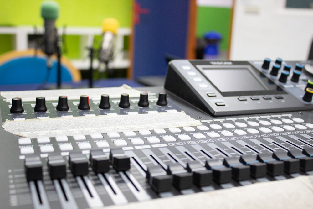 Close-up view of a mixing console in a college radio station. Image comes from Wikimedia Commons
